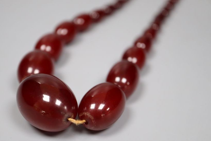 A single strand graduated simulated oval amber bead necklace, 52cm, gross 52 grams.